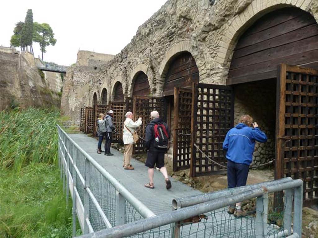 Beachfront, Herculaneum, September 2015. Looking west along the area of the beachfront and six of the twelve “boatsheds”, found under the terrace of the Sacred Area.  “Since the 1980’s the ancient shoreline, coinciding with the southern side of the archaeological site, has been explored leading to the discovery of the boat-houses, the skeletons of the victims, the large wooden boat and the collapsed portico (pronaos) of the Temple of Venus (Sacellum B). 
The resin casts of the skeletons found in the boat-houses, finally placed in situ at the end of 2011, now give visitors a vivid image of the last, painful moments of their lives.”
See Guidobaldi, M.P. and Esposito, D. (2013). Herculaneum: Art of the Buried City. U.S.A, Abbeville Press, (p.21-26).